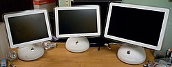 Three white computers arrayed side-by-side; they are identical save for their screens of differing sizes, arranged from smallest to largest